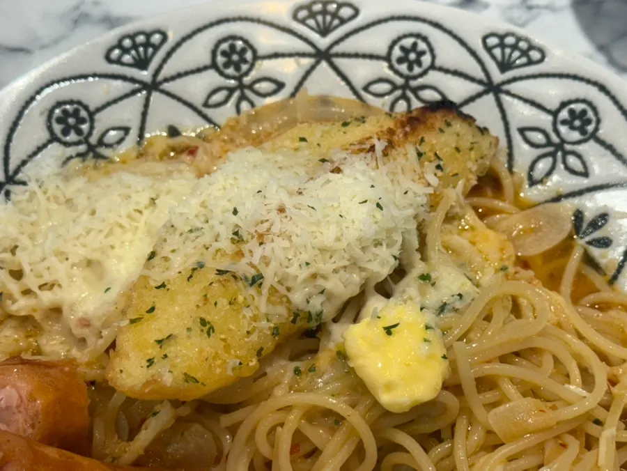 A piece of garlic baguette soaked in sauce