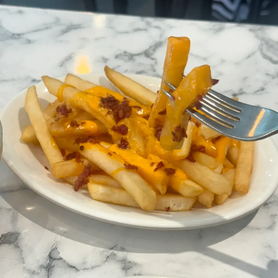 Close-up of crispy bacon topping on the cheese fries