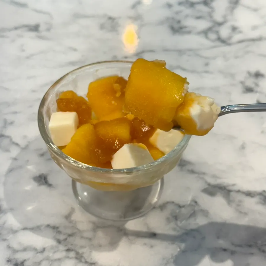 Dessert cup topped with slightly frozen mango