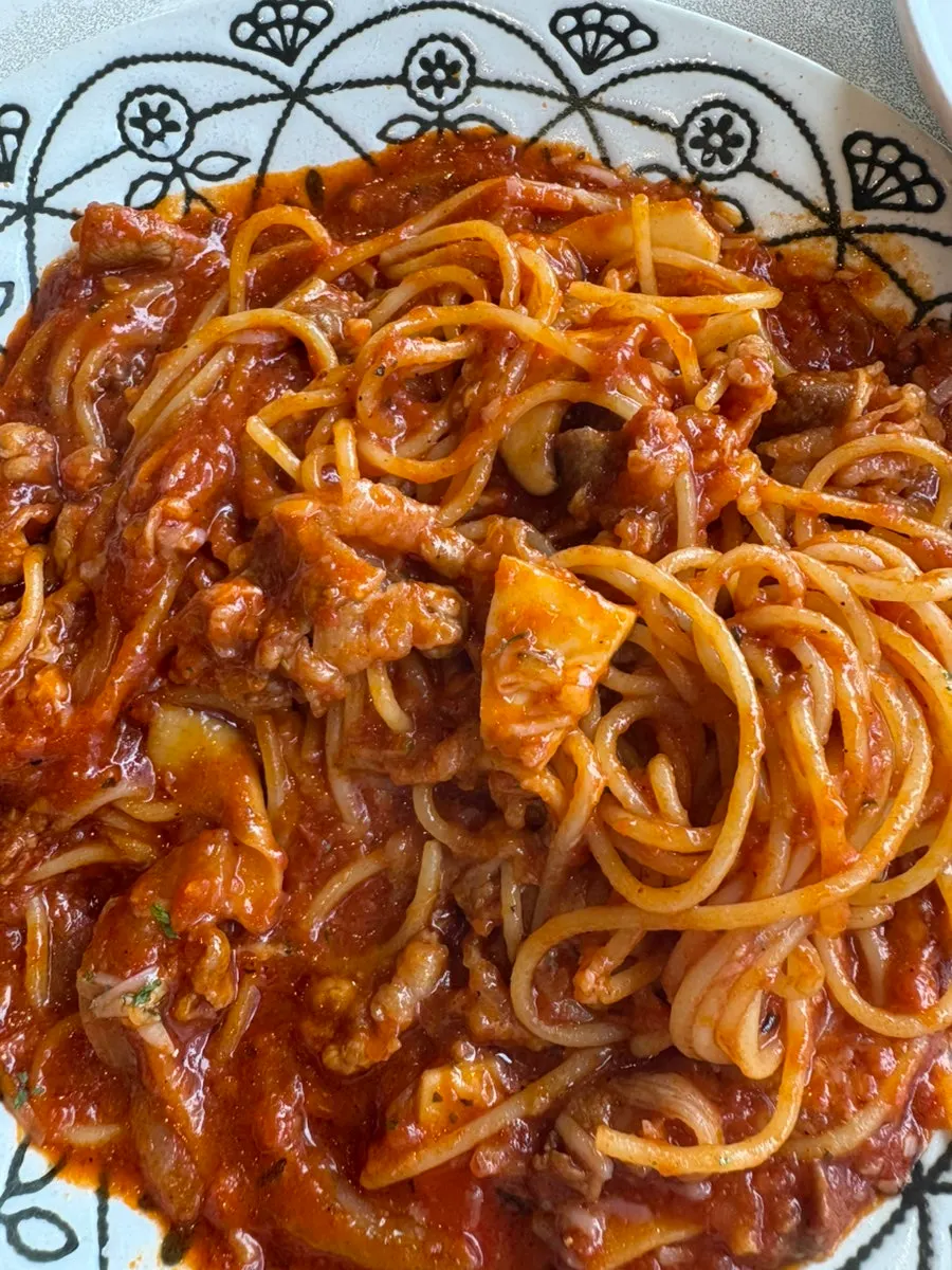 A forkful of noodles lifted from the spicy beef brisket tomato pasta