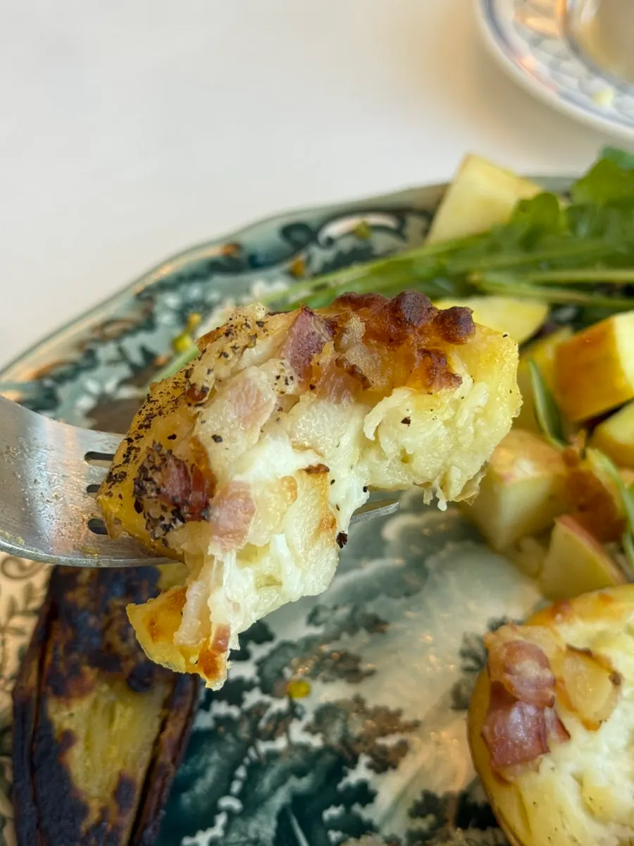 A bite of bread topped with brunch ingredients