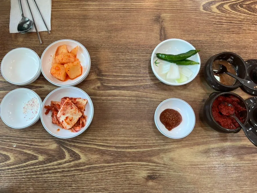 Basic table setting and side dishes at Roman Gukbap