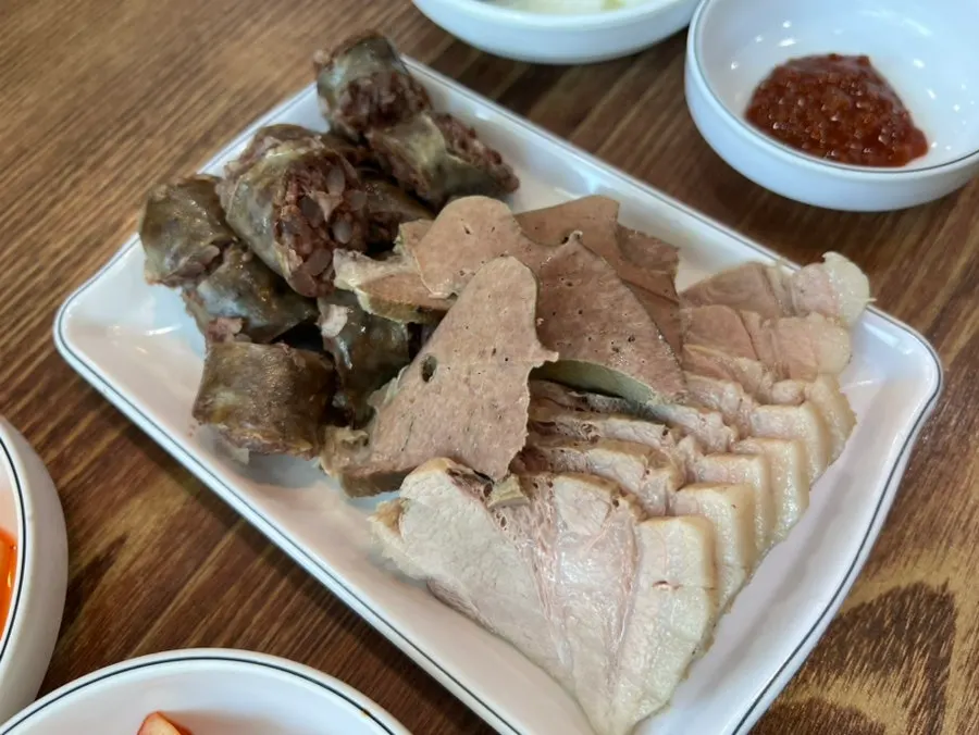 Bowls of clear Roman Gukbap and spicy pork soup side by side