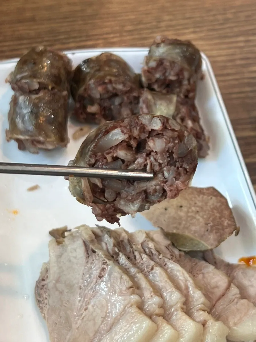 A piece of boiled pork topped with salted shrimp