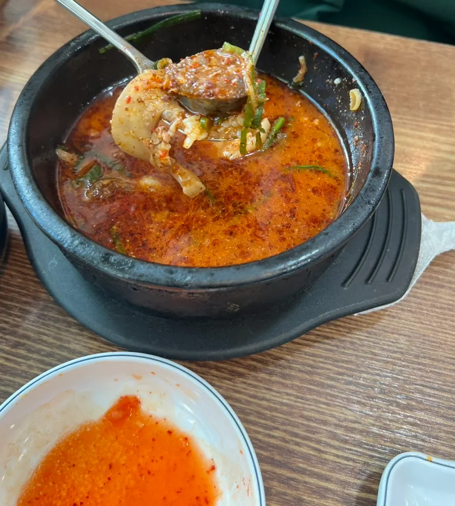 Blood sausage dunked into the spicy soup