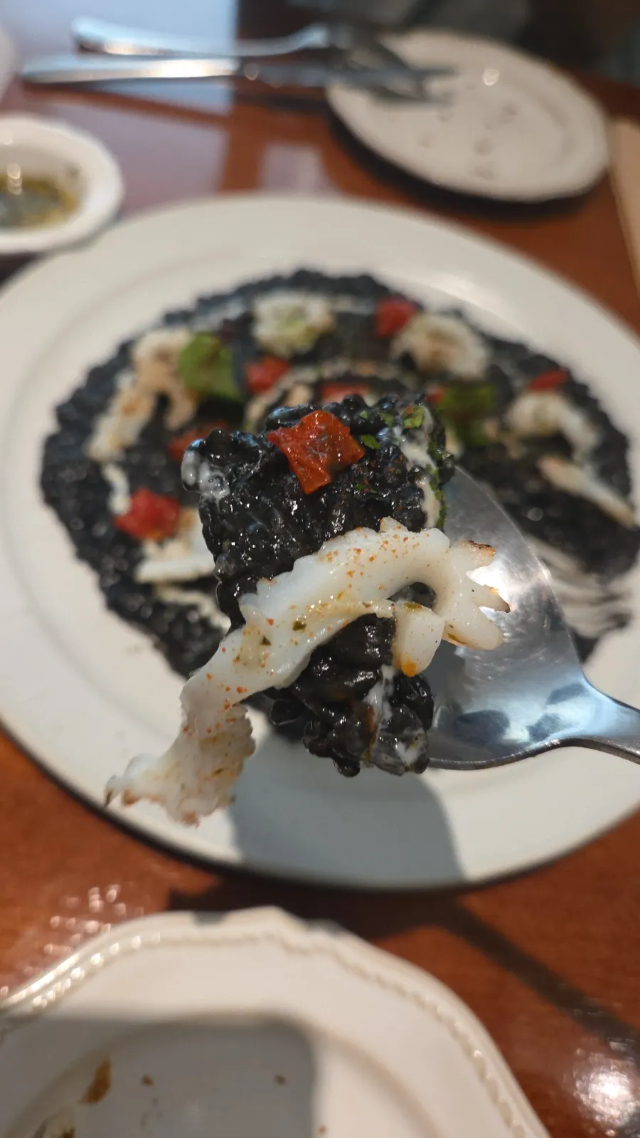 Contrast of pitch-black ink risotto with white cuttlefish