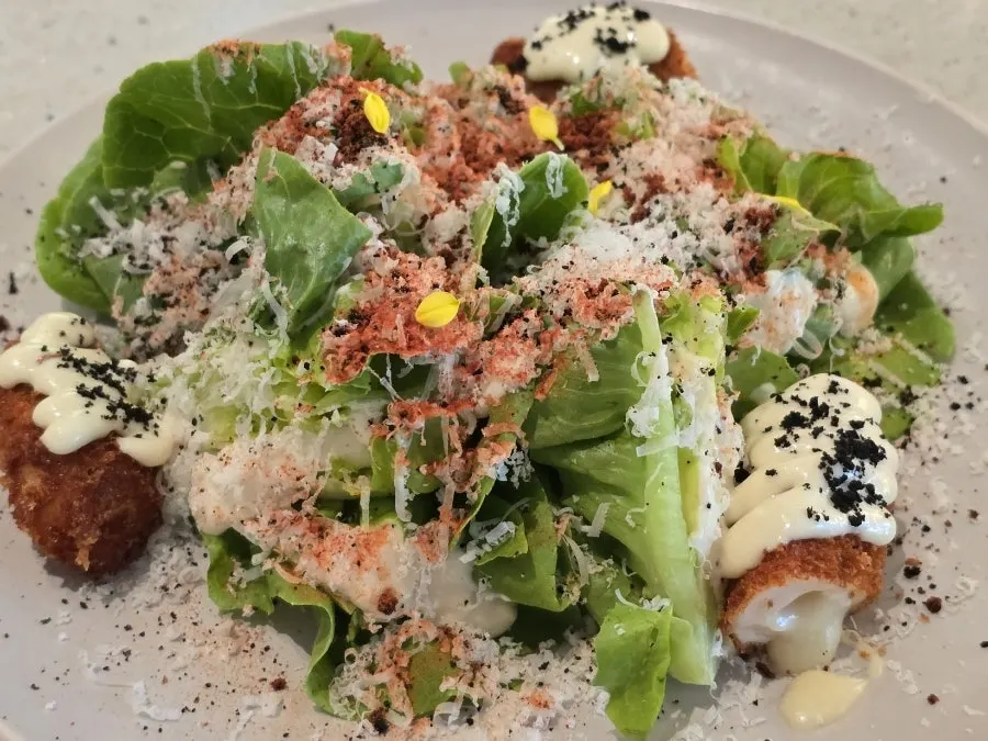 Romaok chicken cordon Caesar salad topped with cheese