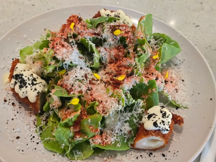Caesar salad with crispy chicken cordon bleu on top