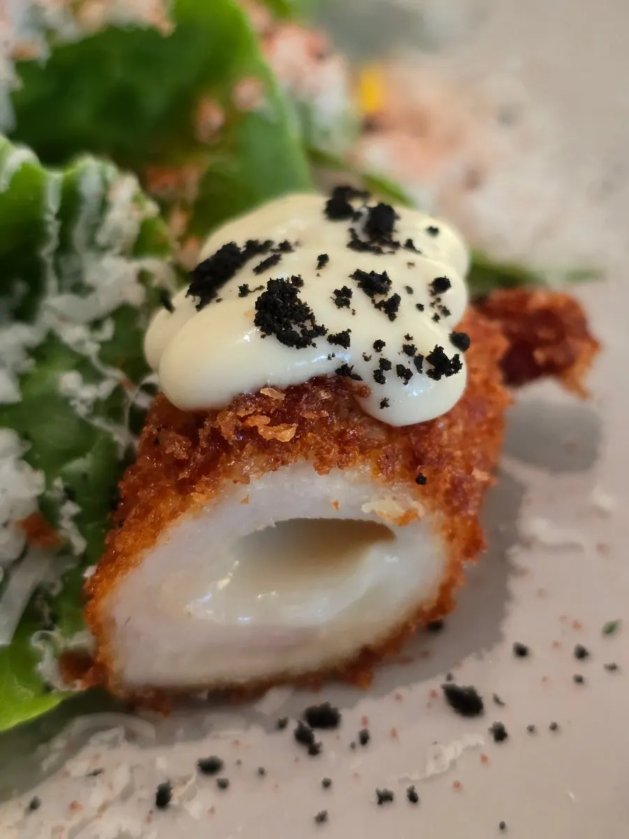 A bite of chicken cordon salad with Caesar dressing