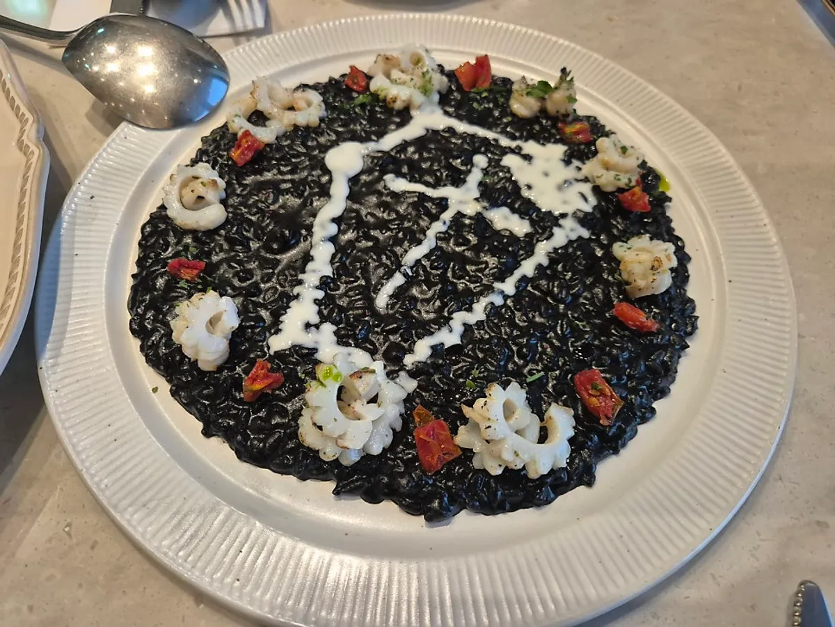 Eclipse squid ink risotto topped with a coffin-shaped design