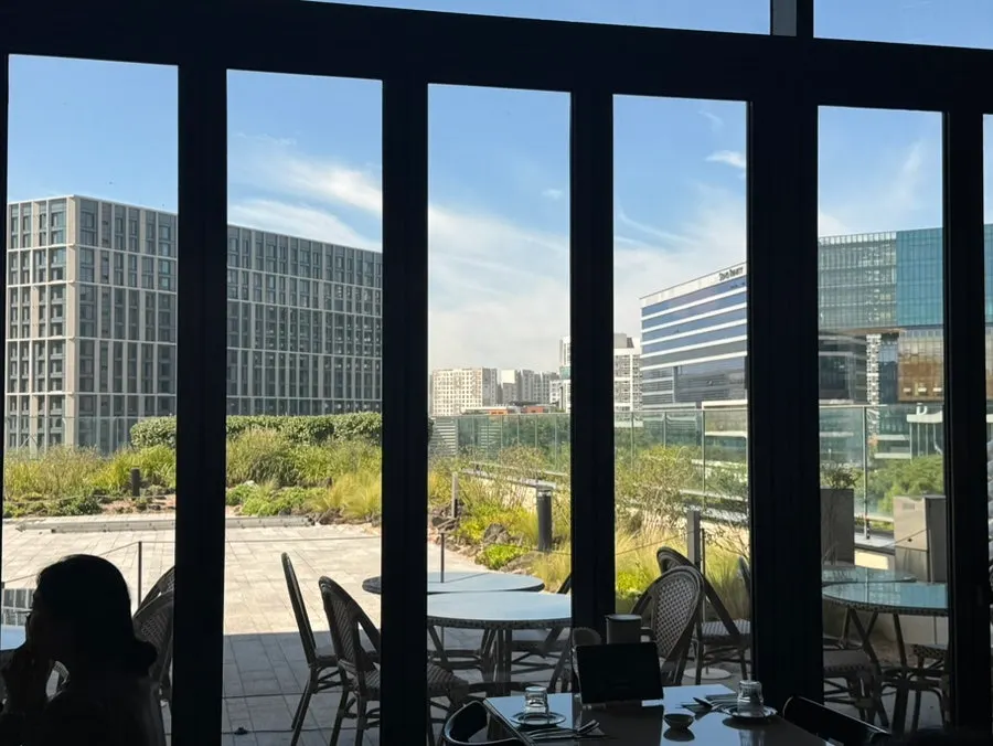 Sunlit seating at Romaok Magok with rooftop view