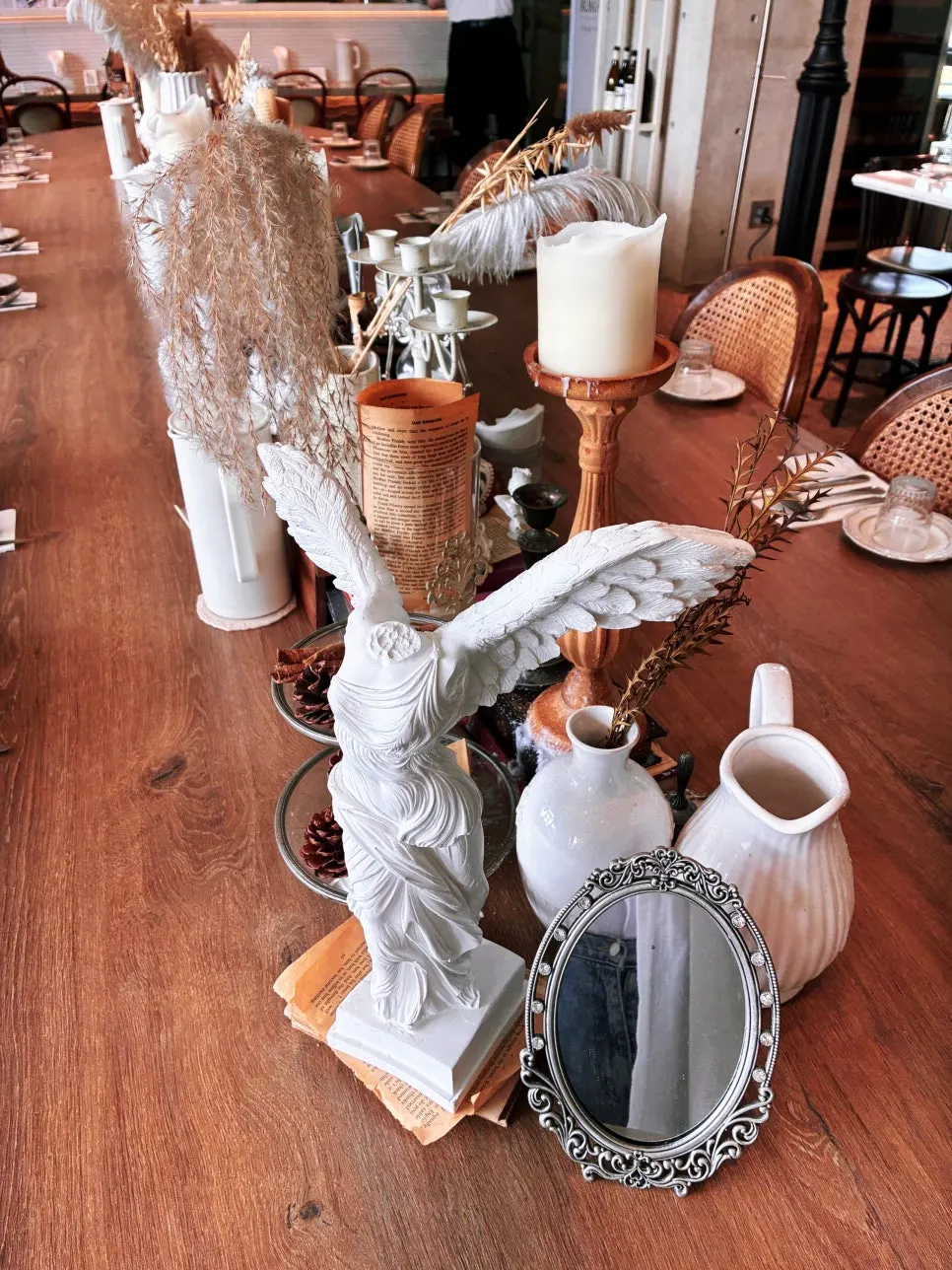 Long wooden table set with candlesticks and dried flowers