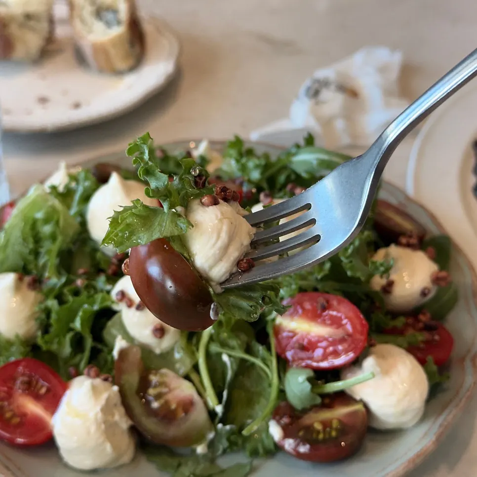 Pine nut caprese salad topped with cherry and black tomatoes