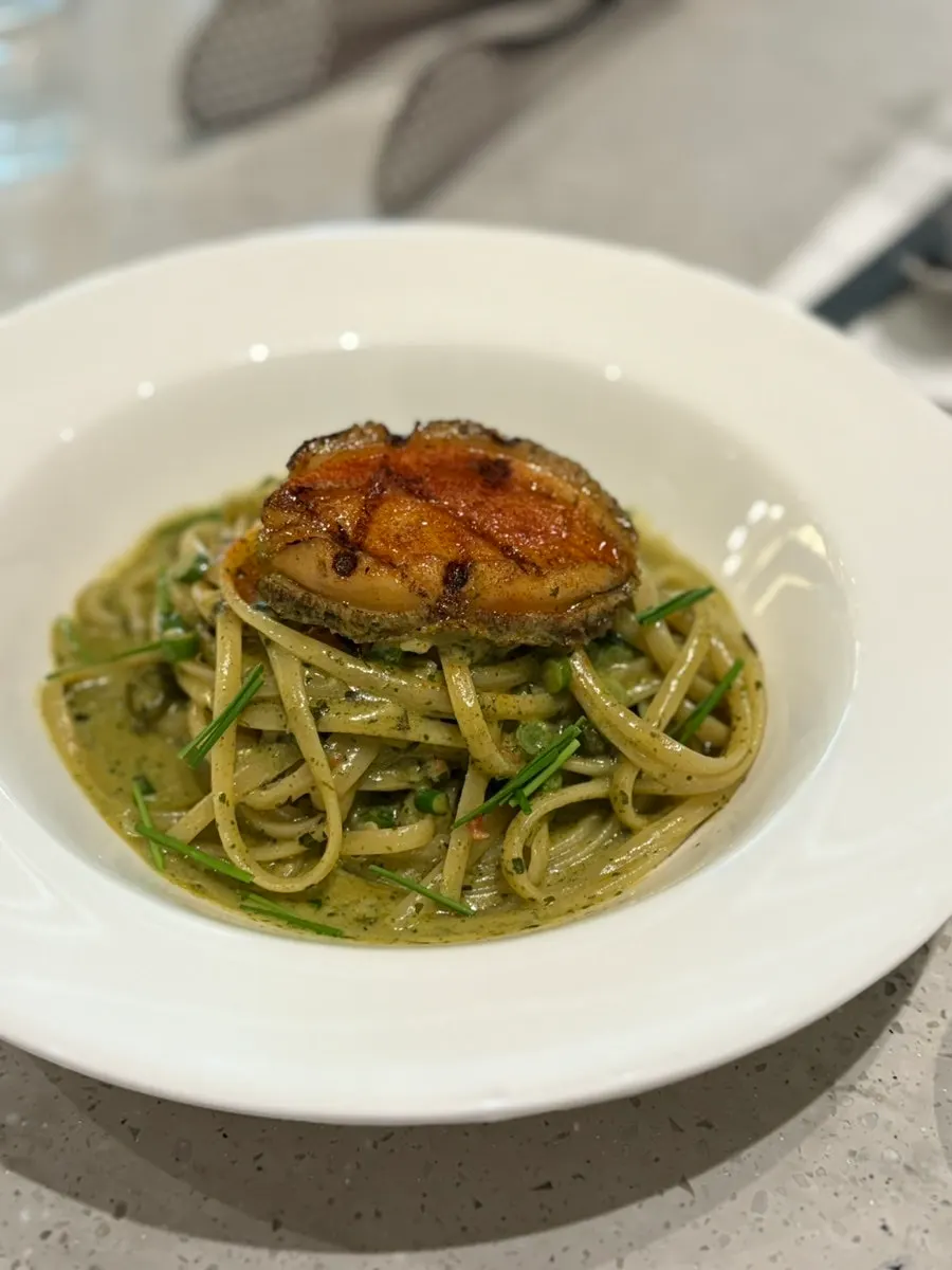 Abalone geou sauce pasta noodles twirled on a fork