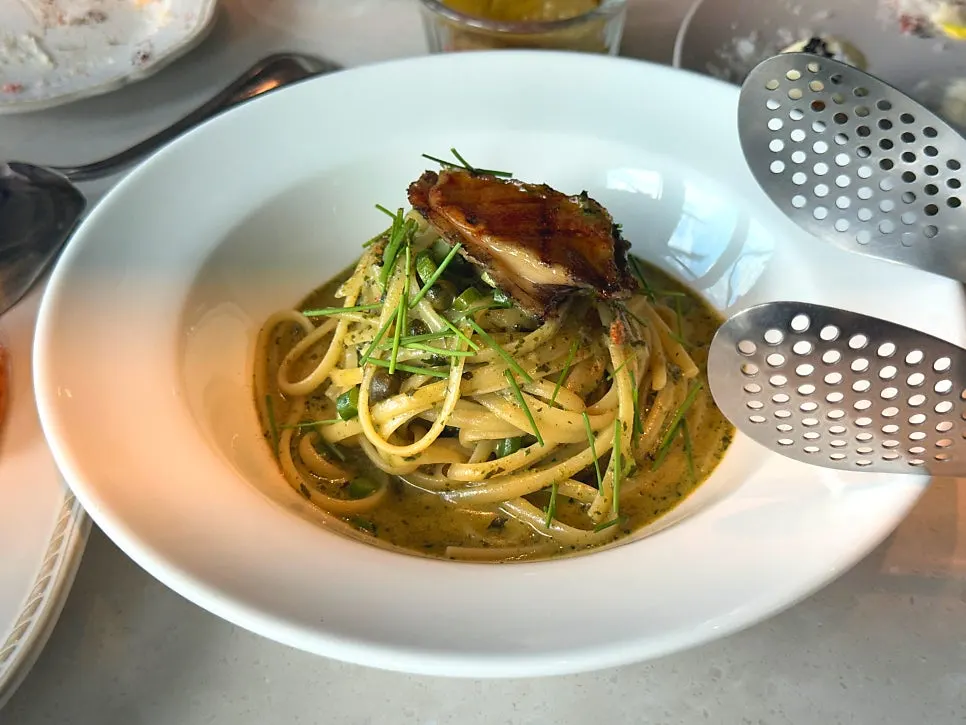 Abalone geou linguine pasta topped with a whole abalone