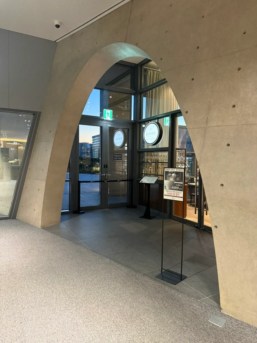 Interior of LG Art Center with tall ceilings and exposed concrete arches