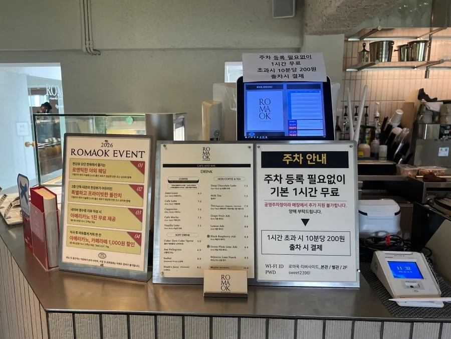 카페 메뉴와 주차 안내가 적힌 안내판