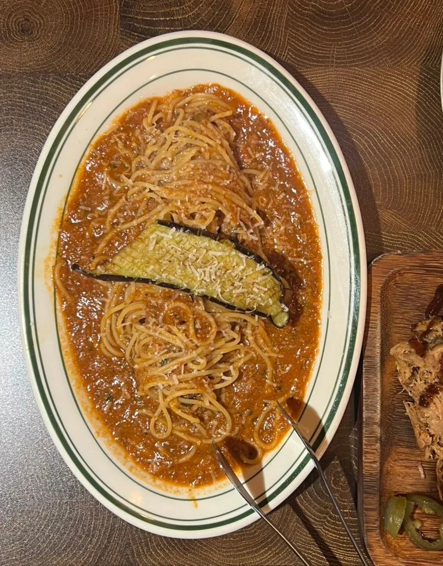 Melanzane ragu pasta topped with eggplant