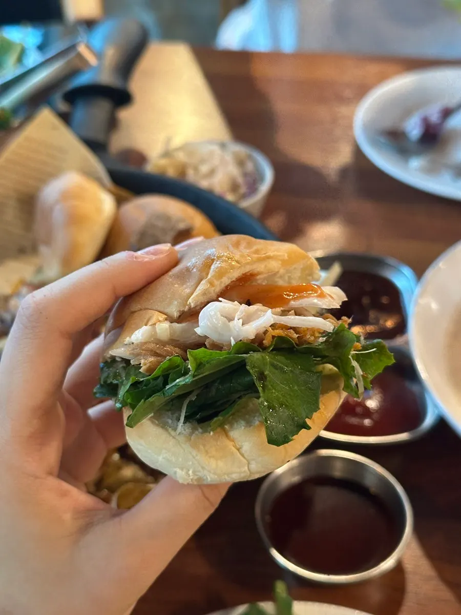 A homemade burger with barbecue and coleslaw on bread
