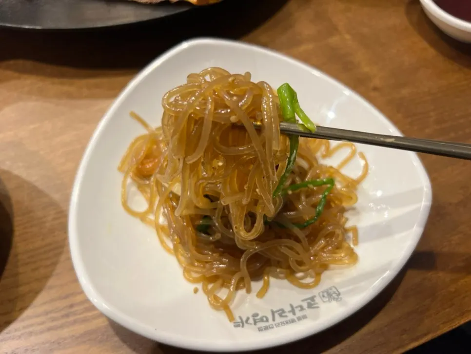 Table with japchae and various banchan