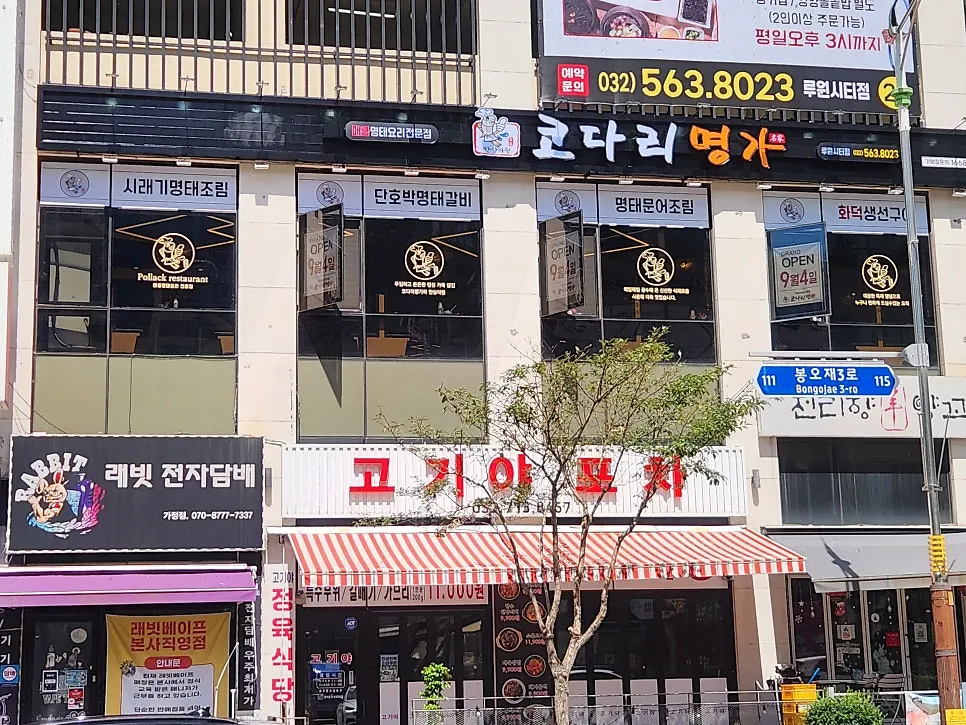 우드톤 테이블과 어두운 벽의 넓은 매장 내부