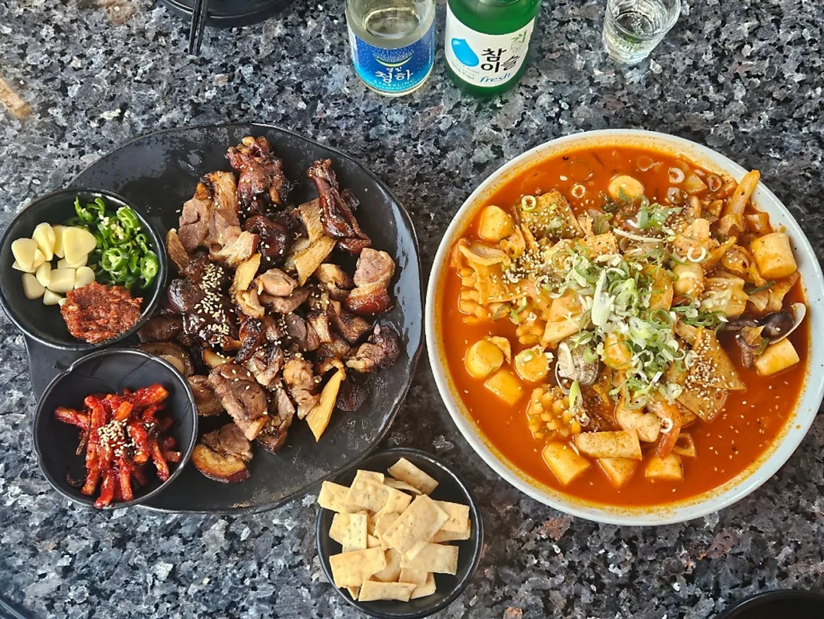 A full table of grilled jokbal and seafood gareotteok-bokki