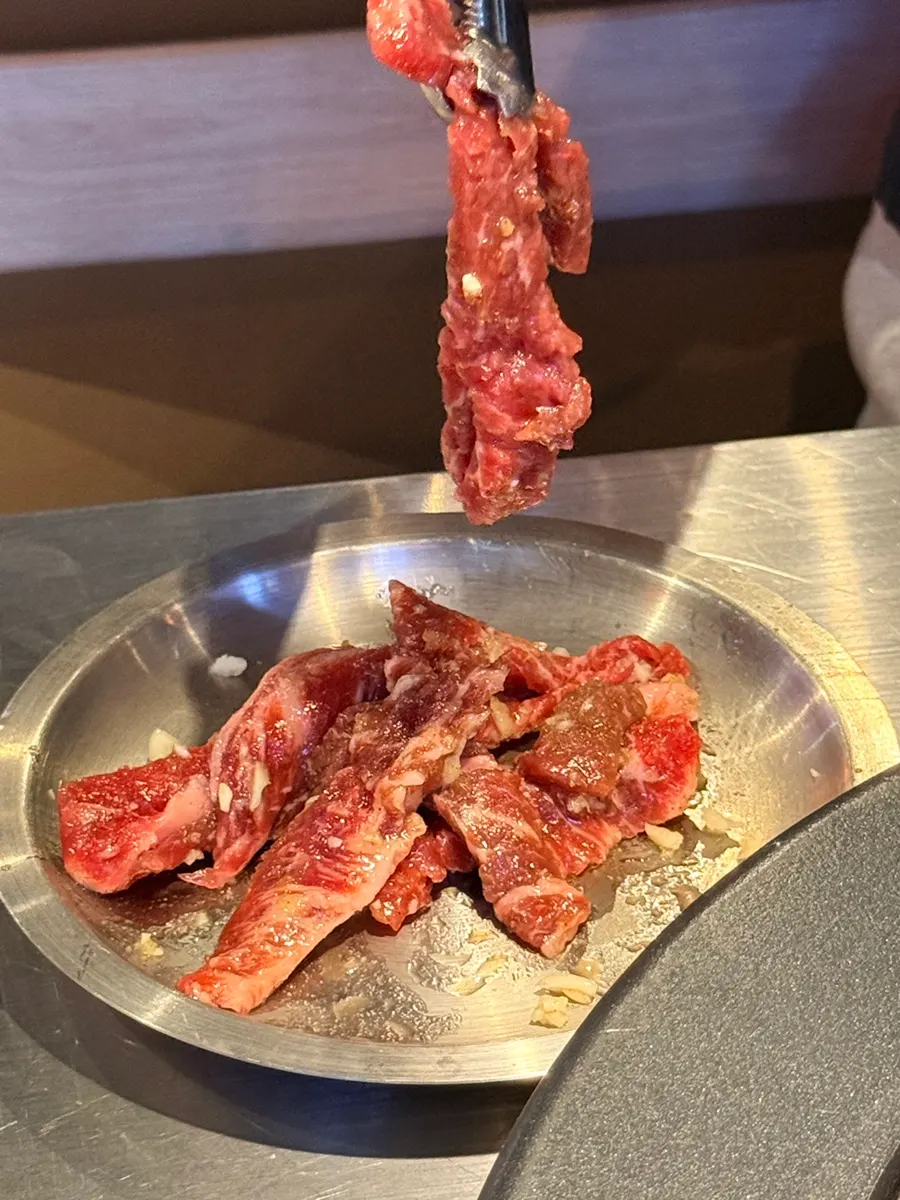 Vertical shot of garlic marinated meat on the charcoal grill