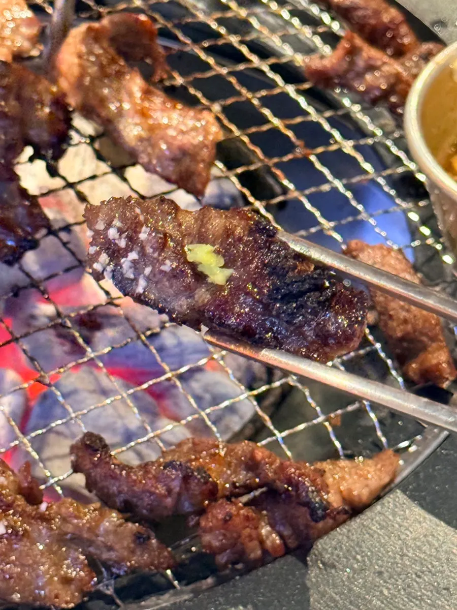 A piece of garlic marinated galbisal dipped in sauce