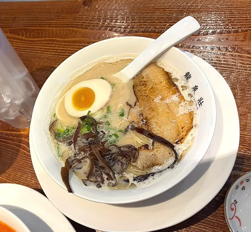 Thin ramen noodles lifted with chopsticks