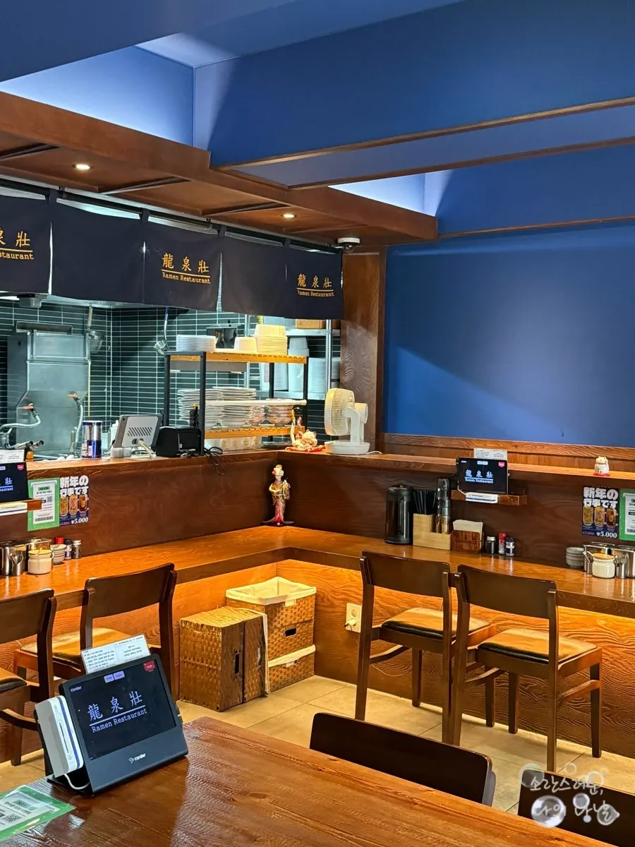 Interior of the ramen shop with bar seating facing the open kitchen