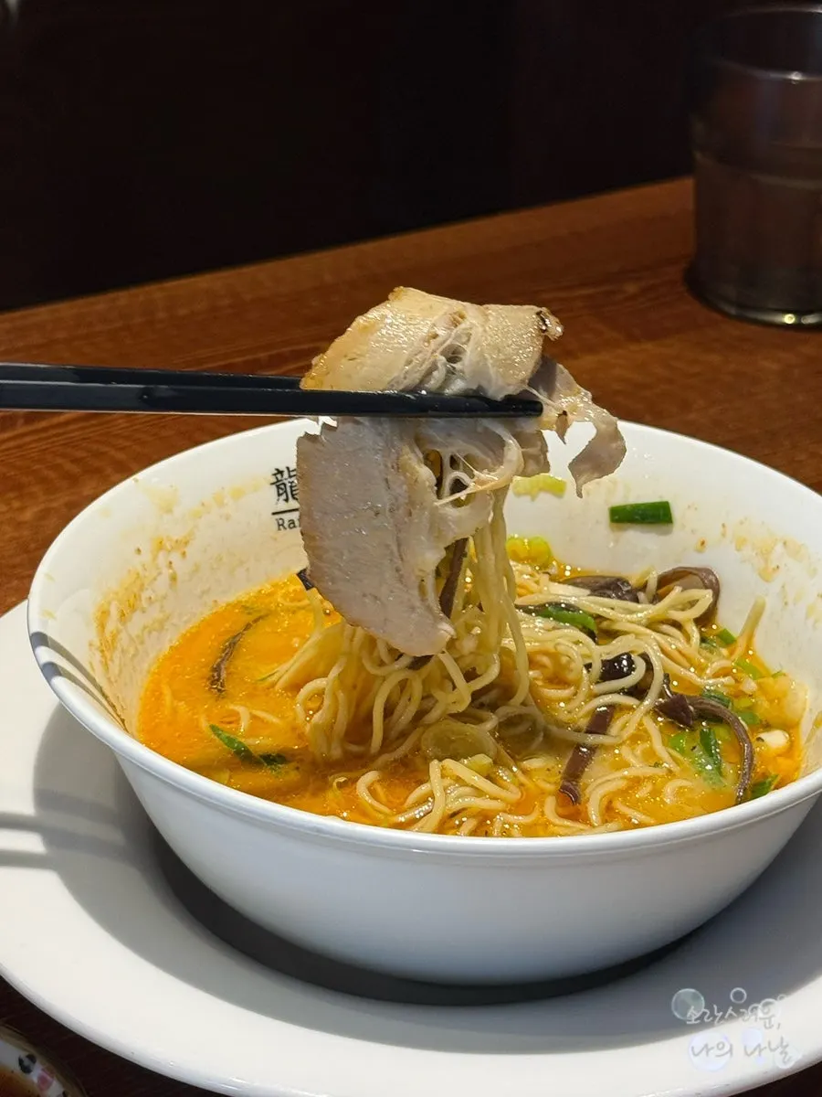 Thin ramen noodles lifted with chopsticks