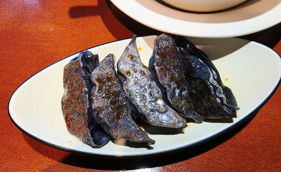 A plate of black-skinned black pork gyoza