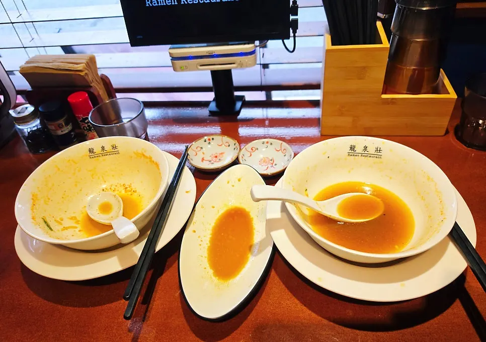 Table spread with two bowls of ramen and gyoza