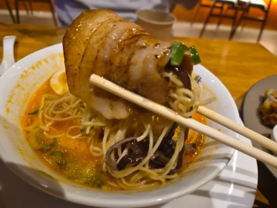 A bite of noodles wrapped in chashu pork