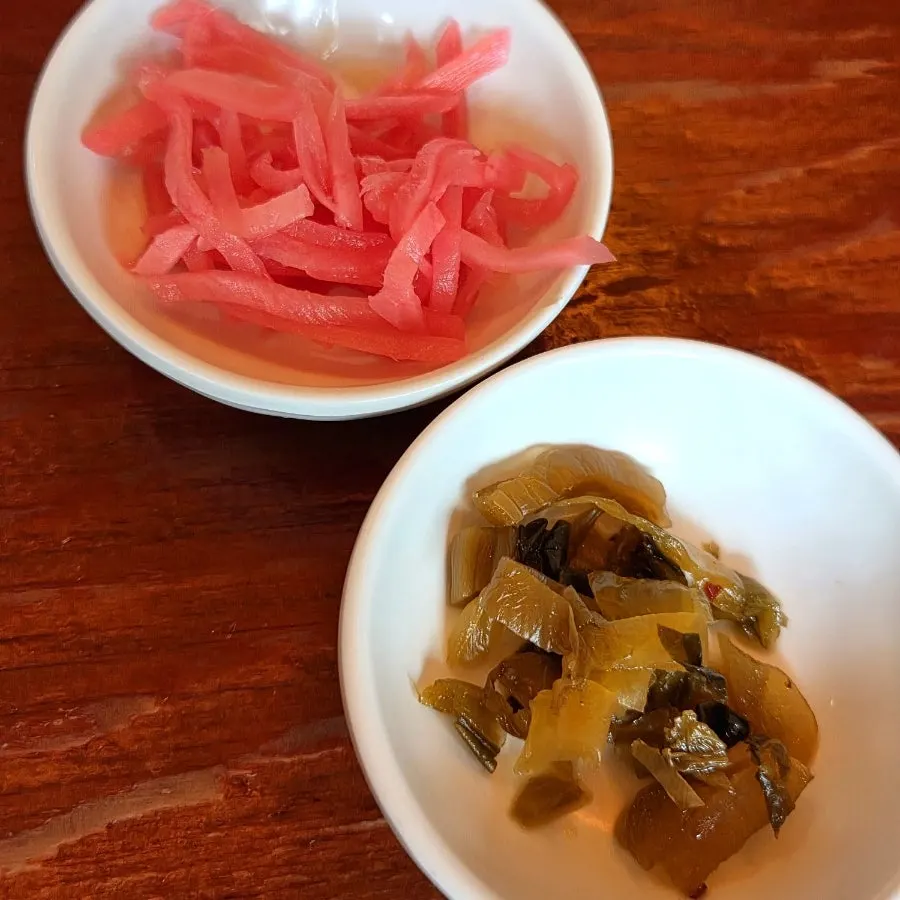 Plate of pickled ginger strips and pickled mustard greens