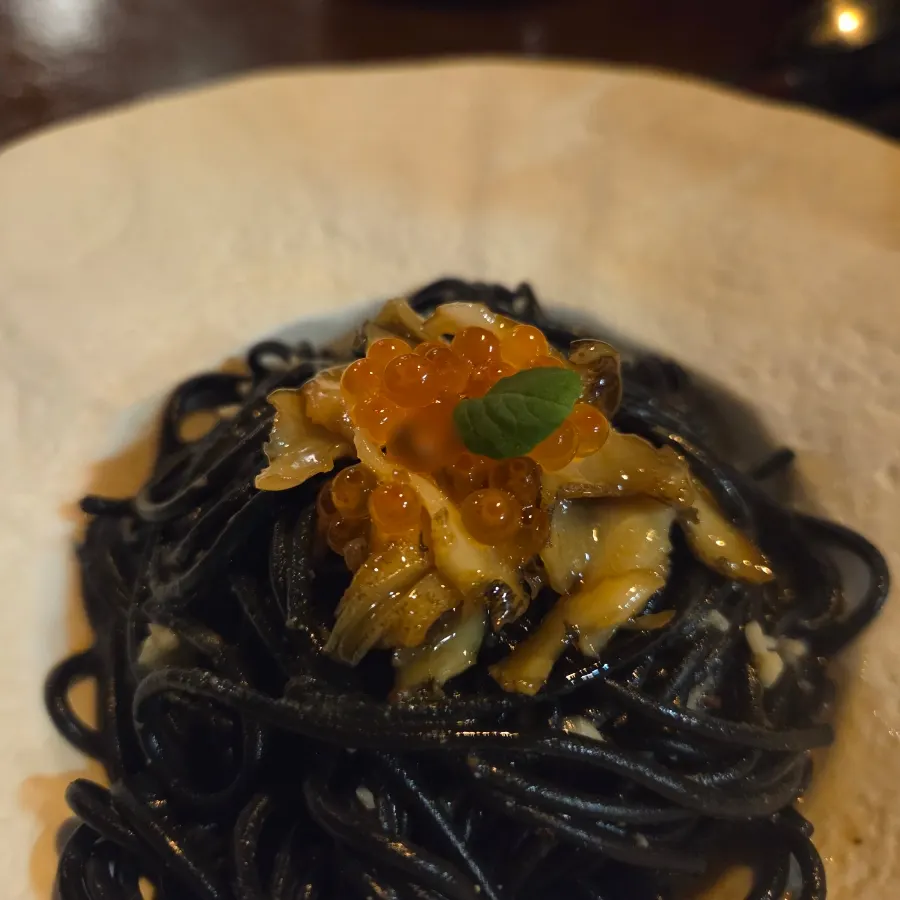Close-up of uni whelk pasta topped with salmon roe