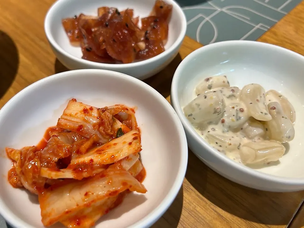 마늘 장아찌가 포함된 사발 밑반찬 세 가지