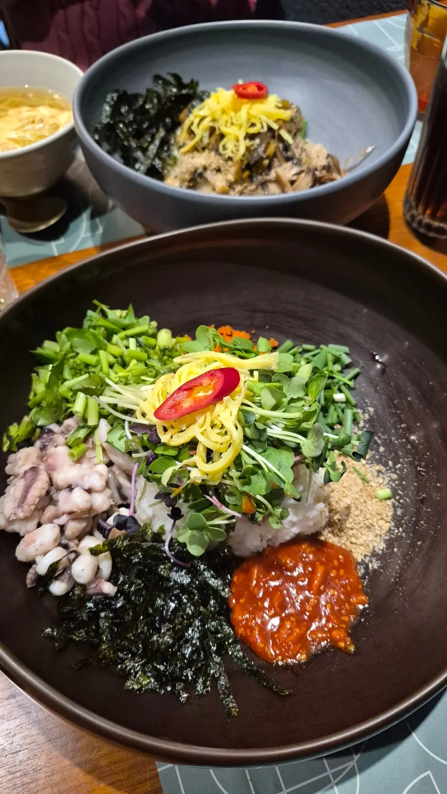 Close-up of tangtang octopus rice with minari and radish sprouts