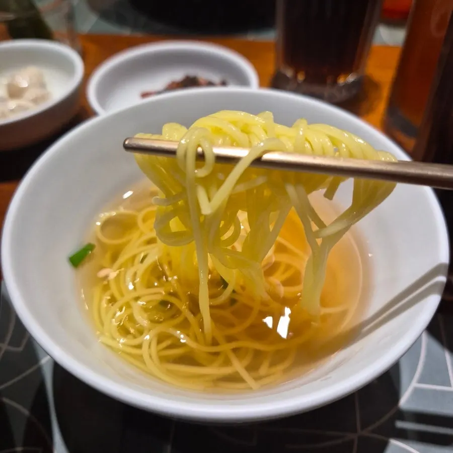 A bowl of mini noodles in clear broth