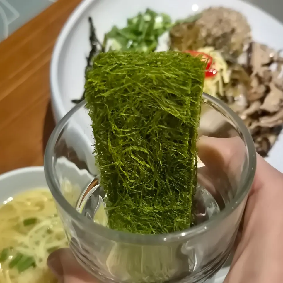 Close-up of bibimbap topped with gamtae and perilla oil