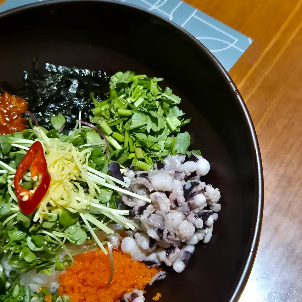 Bibimbap topped with blanched octopus, minari, and flying fish roe