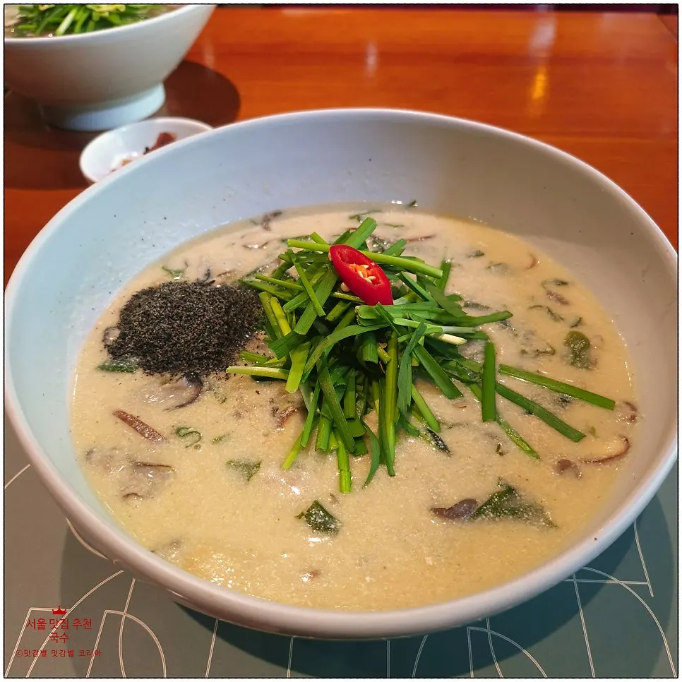 Oyster mushroom black sesame perilla noodle soup in a ceramic bowl