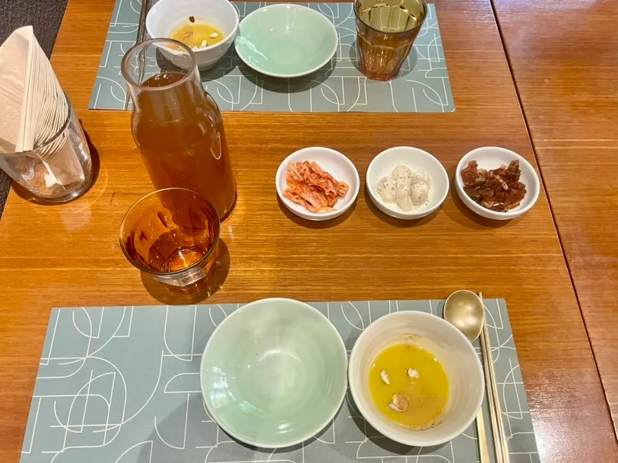 Basic table setting of kimchi, rakkyo, pickles, and pumpkin porridge