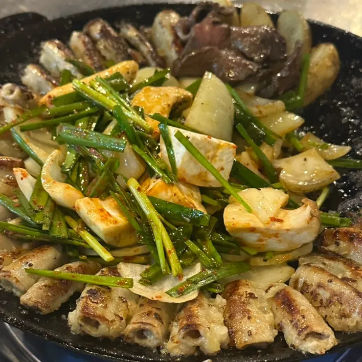Staff-trimmed gopchang and vegetables on the grill