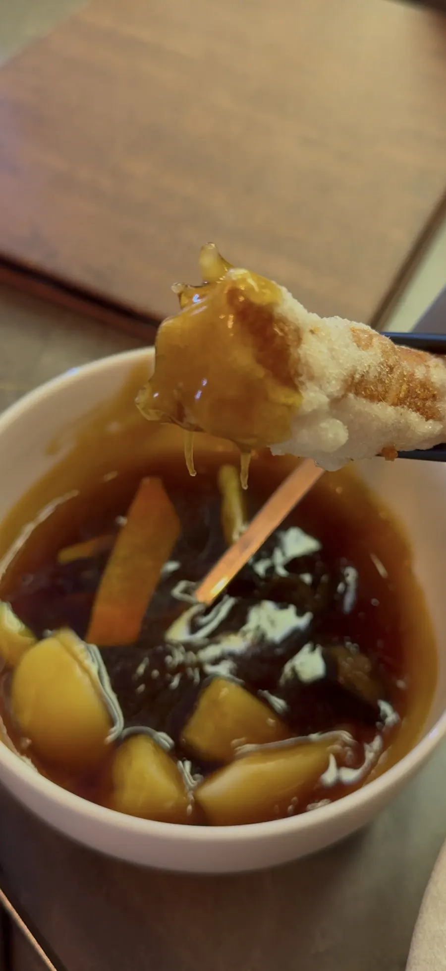 A piece of sweet and sour pork dipped in sauce