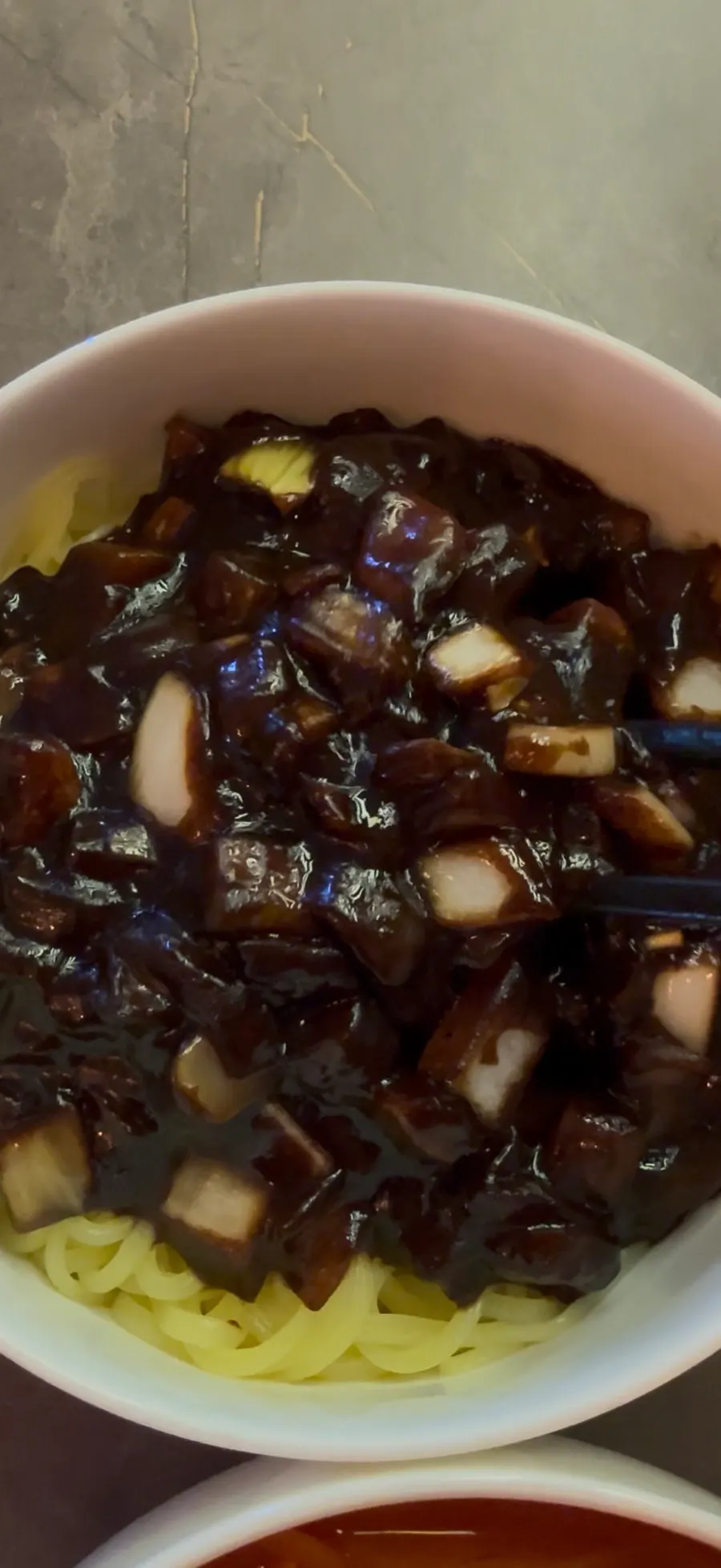 Jjajangmyeon noodles lifted up with chopsticks