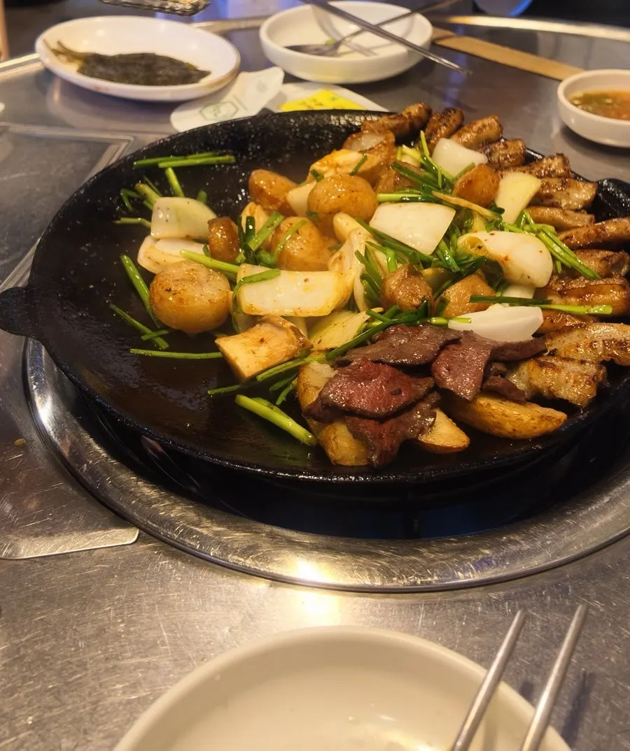 Assorted gopchang and vegetables on the griddle