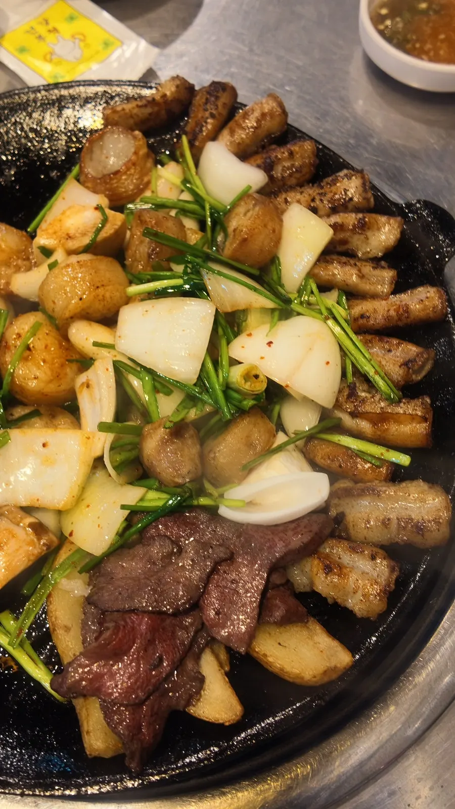 Pre-grilled gopchang on an iron griddle