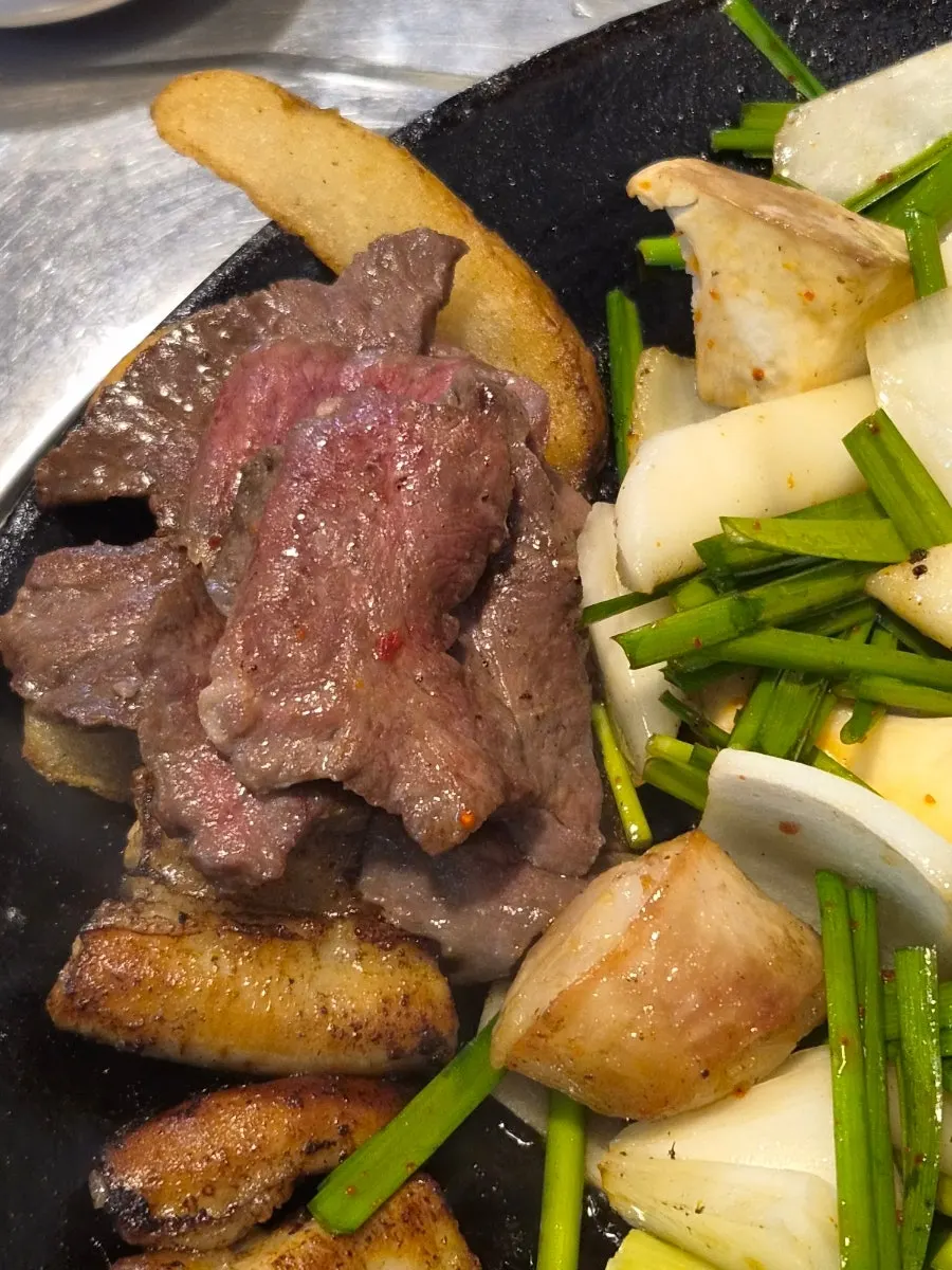 Gopchang and vegetables cooking on the grill
