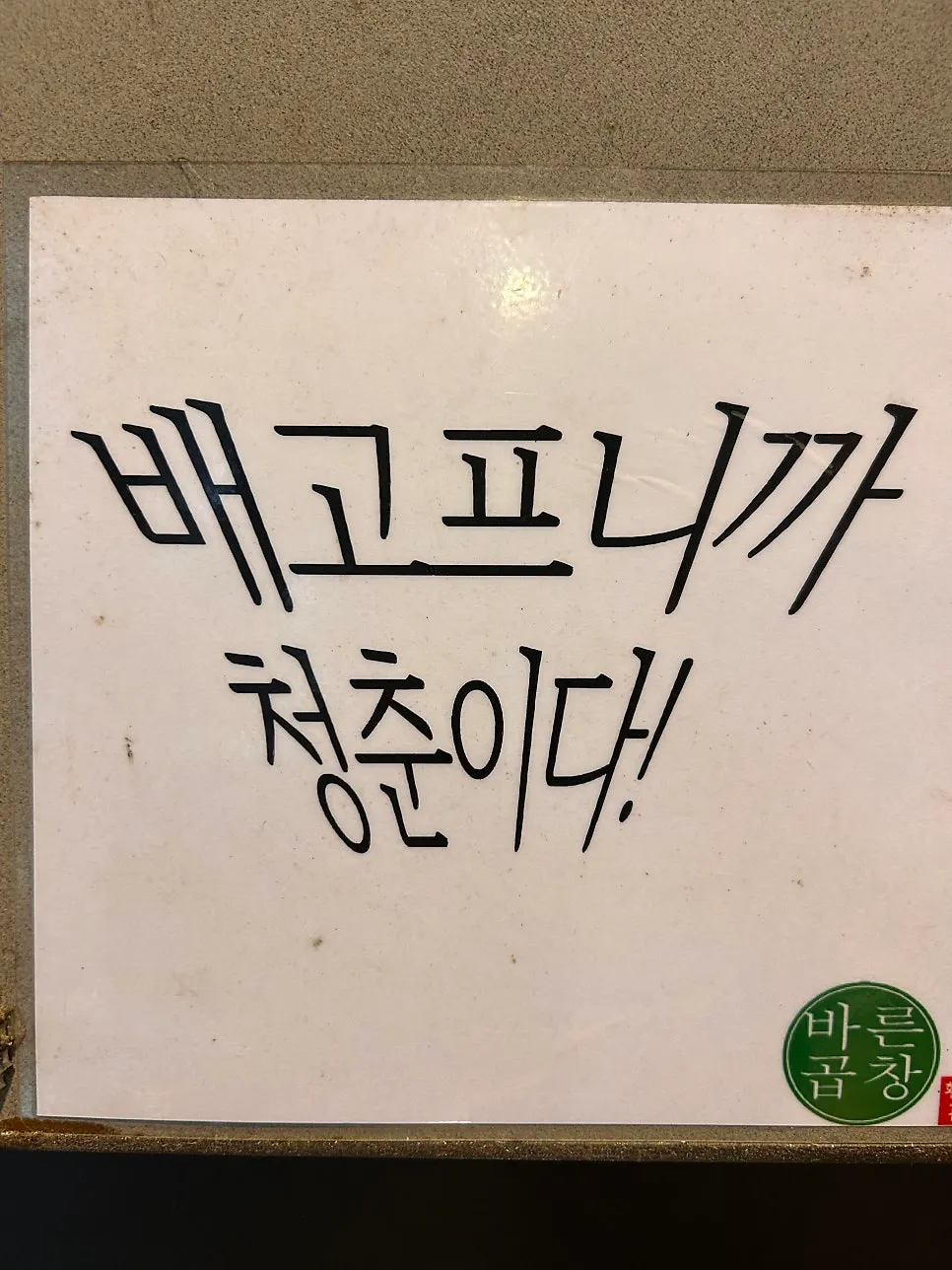 焼酎の蓋とフレーズでいっぱいの店の壁